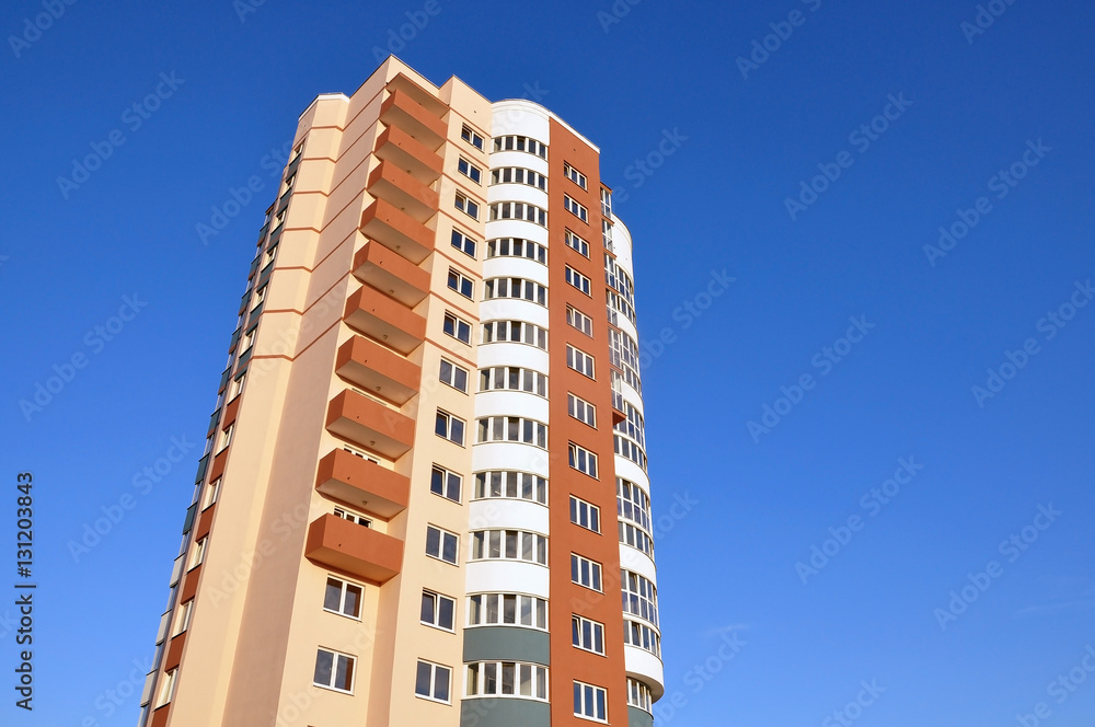 A modern multistory apartment house with round balconies against the blue sky. Lookup. Place for text. A modern multistory apartment house with round balconies against the blue sky. Lookup. Place for text.