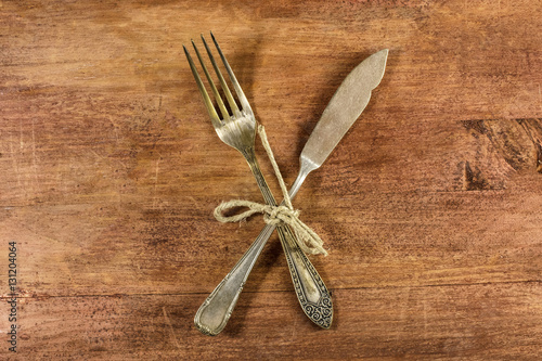 Vintage fork and knife on wooden background