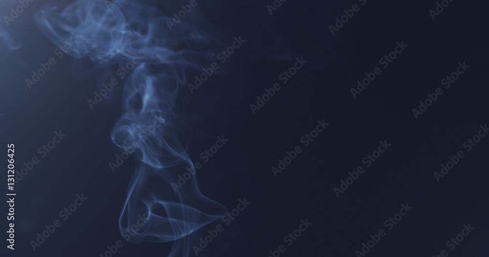 mystery blue smoke over dark background with copy space