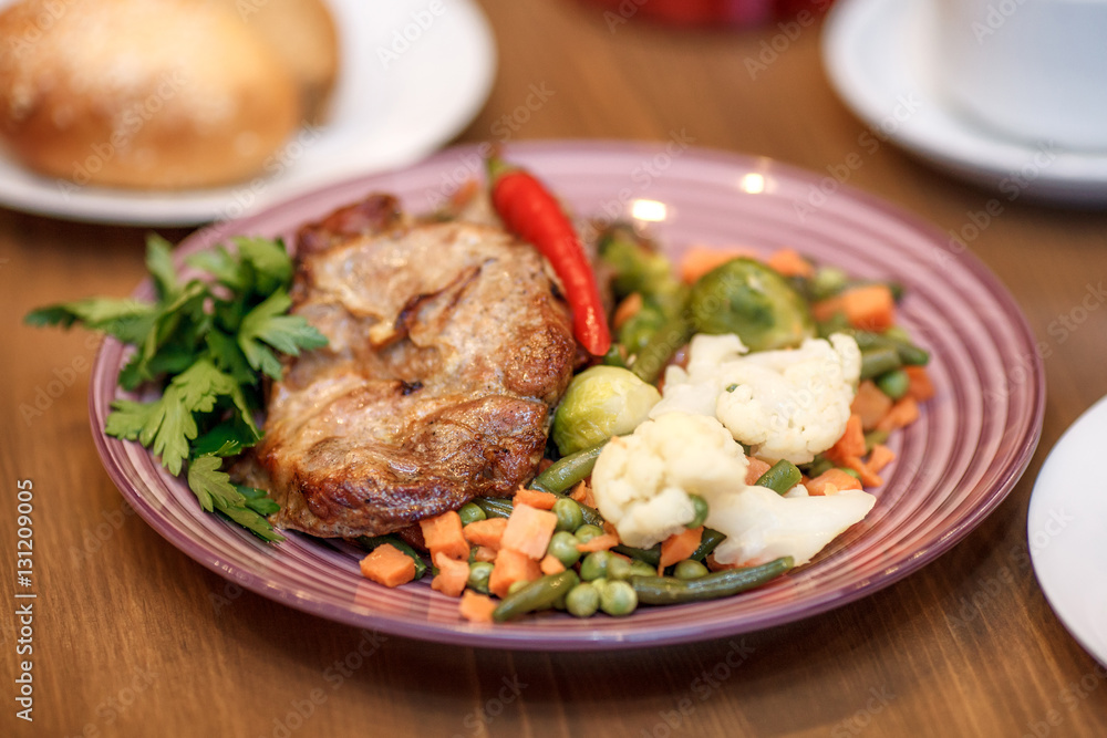 Grilled steak with vegetables and herbs on plate Grilled steak with vegetables and herbs on plate