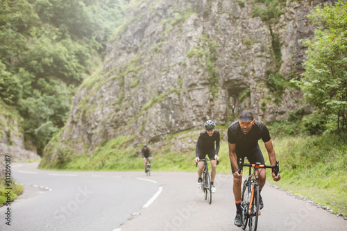 Fototapeta Naklejka Na Ścianę i Meble -  Three road cyclists attacking the climb in Cheddar Gorge