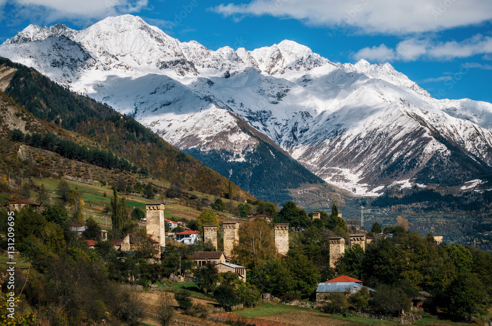 View of the Svanetian towers in Mestia village against mountains with glaciers snow peaks. Upper Svaneti, Georgia. Georgian landmark
