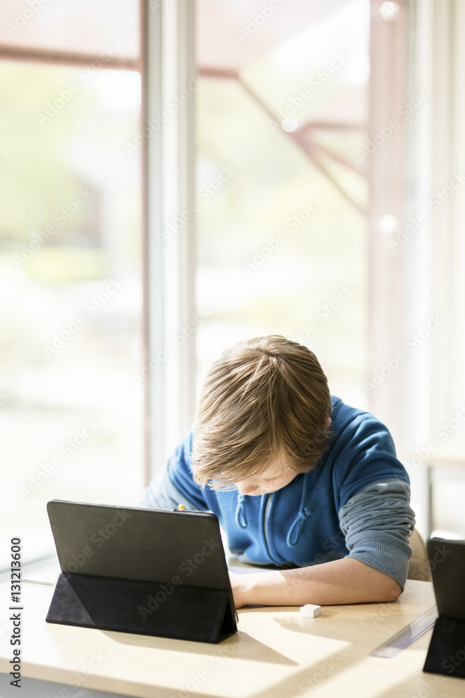 Boy using digital tablet for learning in classroom Boy using digital tablet for learning in classroom