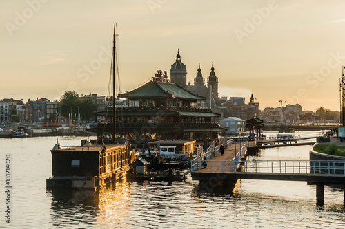 Sunset at The Eastern Dock in Amsterdam with a houseboat  in gol