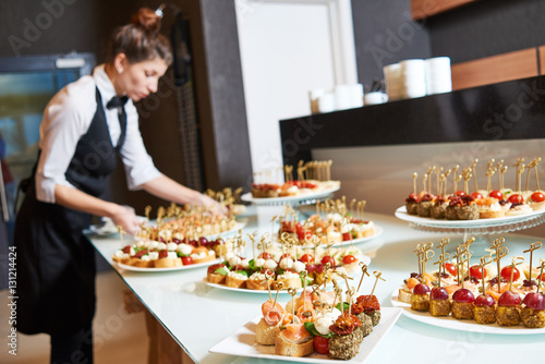 Restaurant waitress serving table with food
