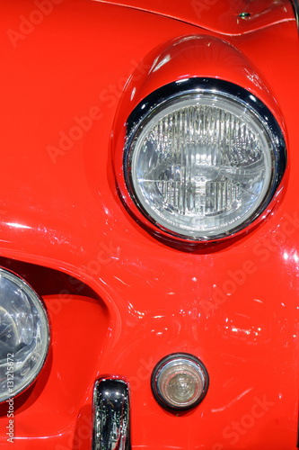 Closeup of light on red car. Beautiful modern red car headlights