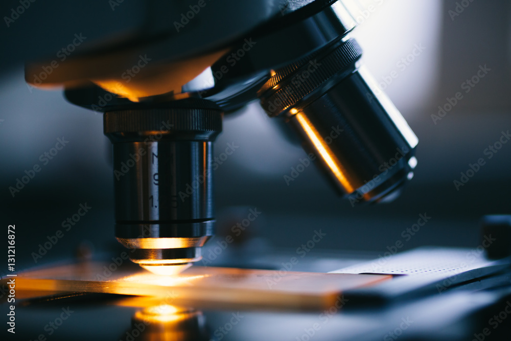 Close up of examining of test sample under the microscope in laboratory. Close up of examining of test sample under the microscope in laboratory.
