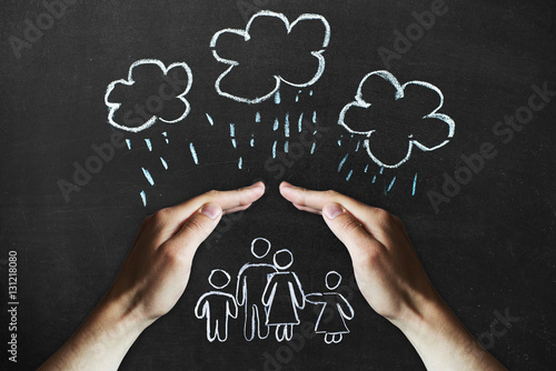 Foto hands protects a family from the elements - rain or storm