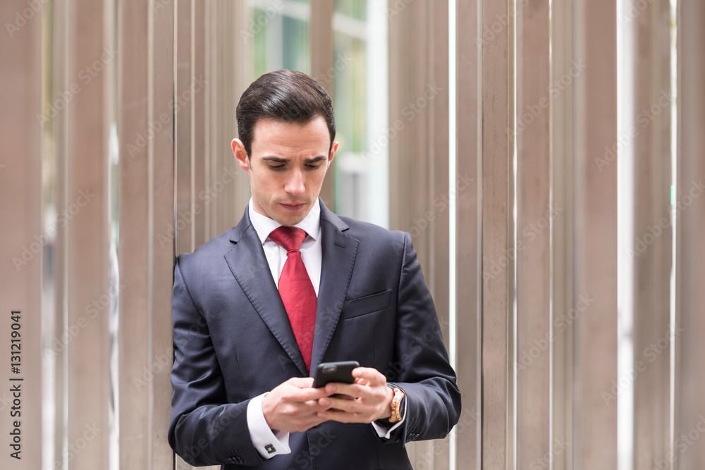 Businessman in city looking at smartphone Businessman in city looking at smartphone