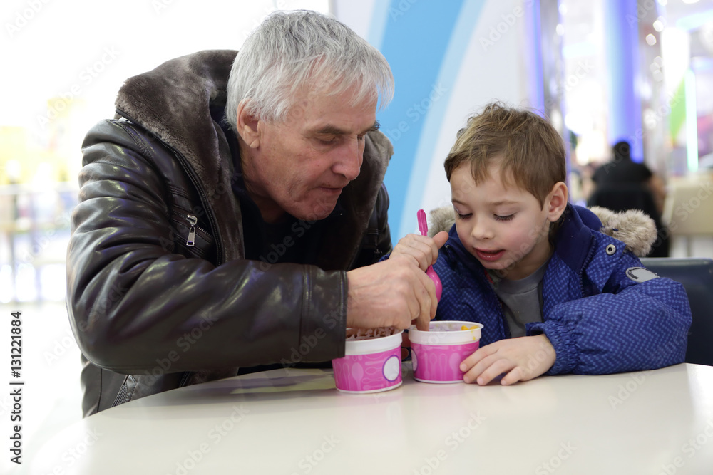 Naklejka premium Grandfather and grandson have ice cream