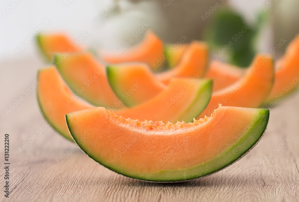 Fresh orange japanese melons sliced on wooden table Fresh orange japanese melons sliced on wooden table
