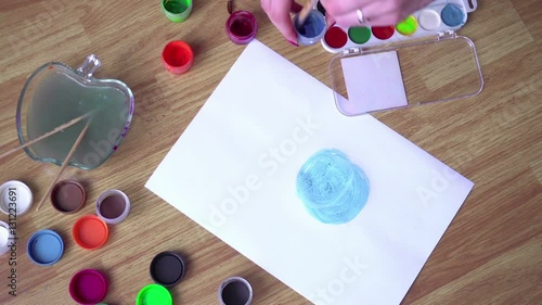 girl draws a bright gouache on paper time laps photo