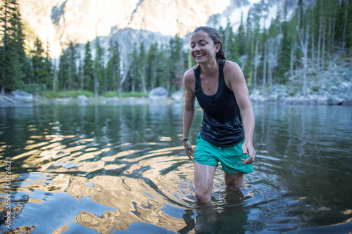 Young woman wading through lake, The Enchantments, Alpine Lakes Wilderness, Washington, USA