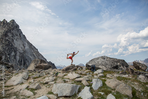 Young woman standing on rock, in yoga pose, The Enchantments, Alpine Lakes Wilderness, Washington, USA