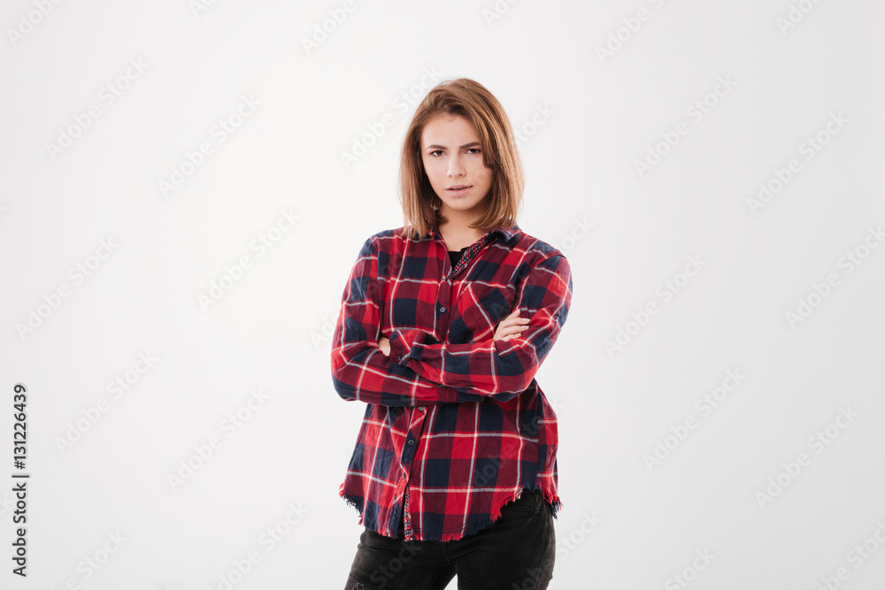 Portrait of a serious young woman standing with arms folded Portrait of a serious young woman standing with arms folded