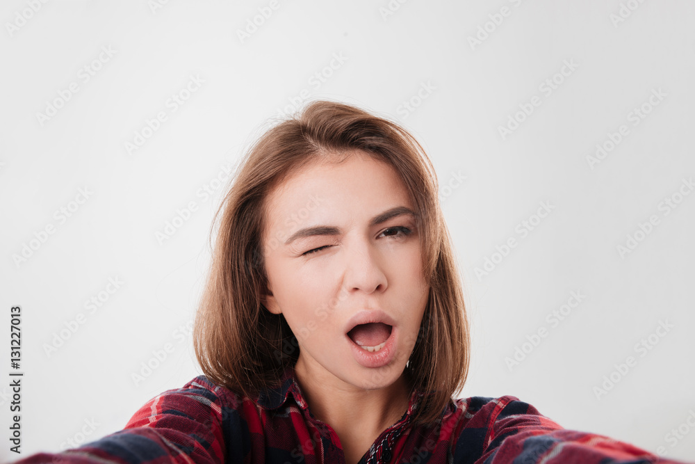 Smiling funny girl winking and taking selfie Smiling funny girl winking and taking selfie