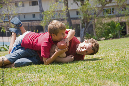 Boy tackling father playing american football in park