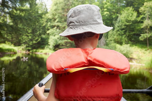 Young boy in canoe, rear view