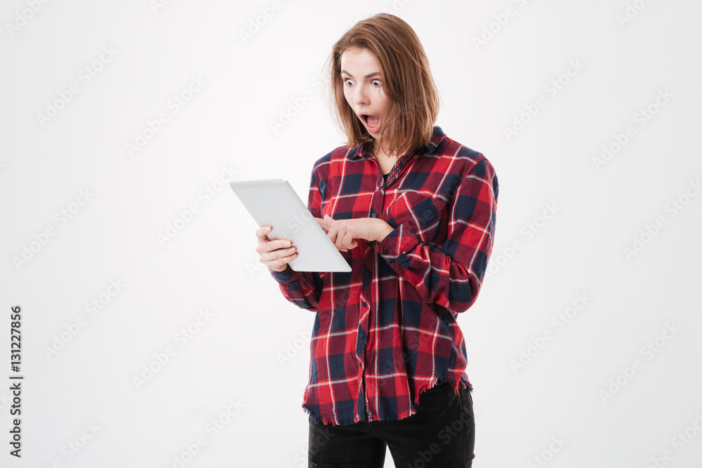 Portrait of a young surprised woman holding digital tablet Portrait of a young surprised woman holding digital tablet