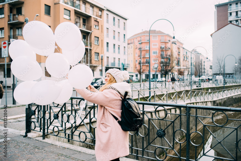 young beautiful caucasian blonde hair woman outdor in the city holding white balloon - happiness, celebration, party concept