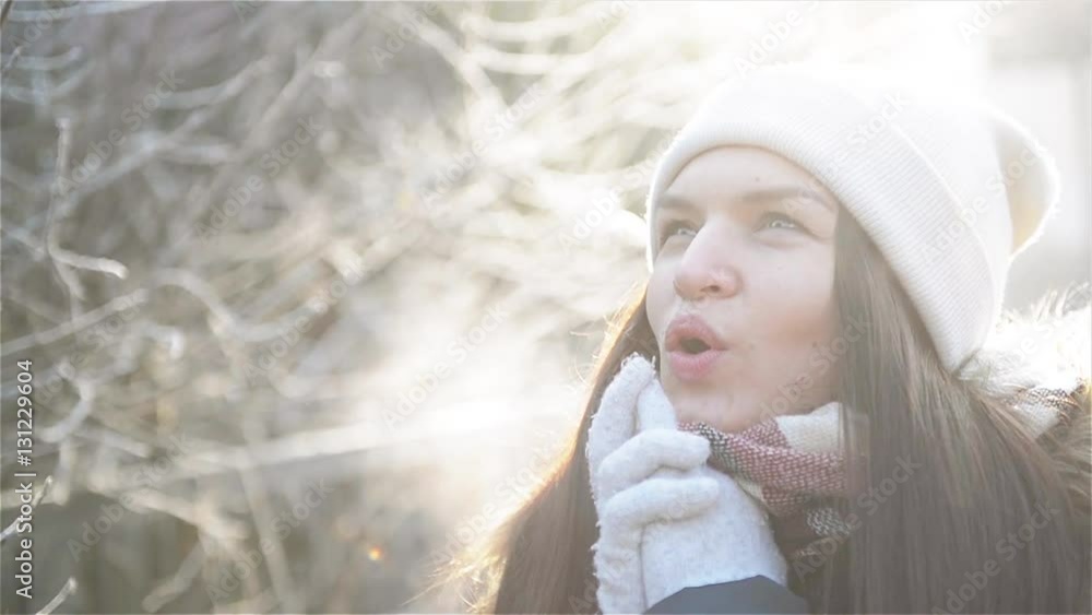 Beautiful Woman Trying to Warm Her Frozen Hands with a Breath in Winter Morning Outdoor. Amazing Girl with Frosty Breathing Enjoying Cold Sunny Weather in the Park. Beautiful Woman Trying to Warm Her Frozen Hands with a Breath in Winter Morning Outdoor. Amazing Girl with Frosty Breathing Enjoying Cold Sunny Weather in the Park.