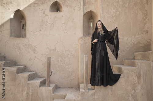 Woman in traditional dress called abaya in Jabreen castle photo