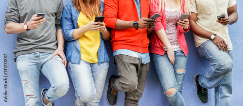 Group of multiracial students watching smart mobile phones photo