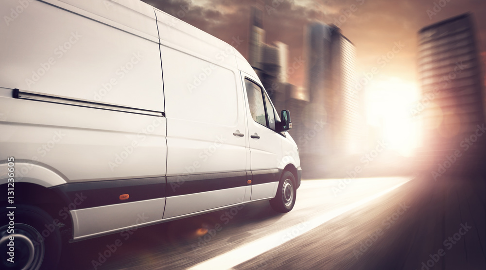 Naklejka premium Delivery truck driving at sunset in a city