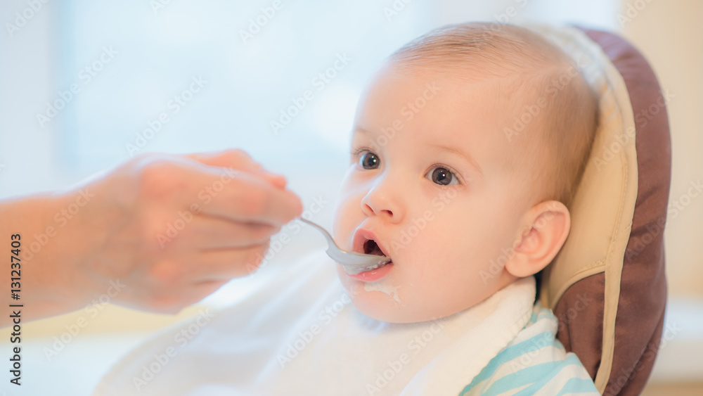 grandmother gives baby food from a spoon