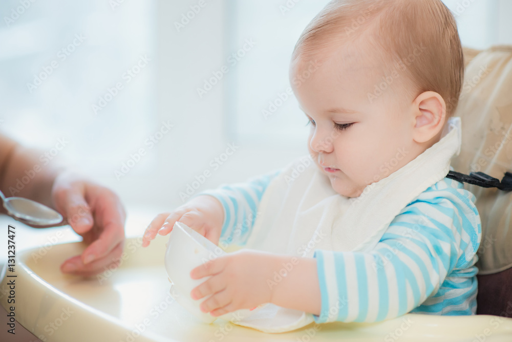 grandmother gives baby food from a spoon grandmother gives baby food from a spoon