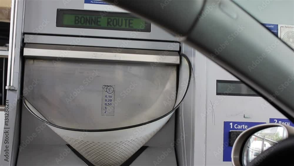 Driver hand toss coins in toll road booth basket in France Europe. Stop