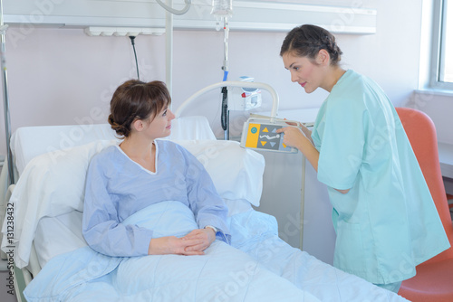 Nurse showing patient the hospital bed controls