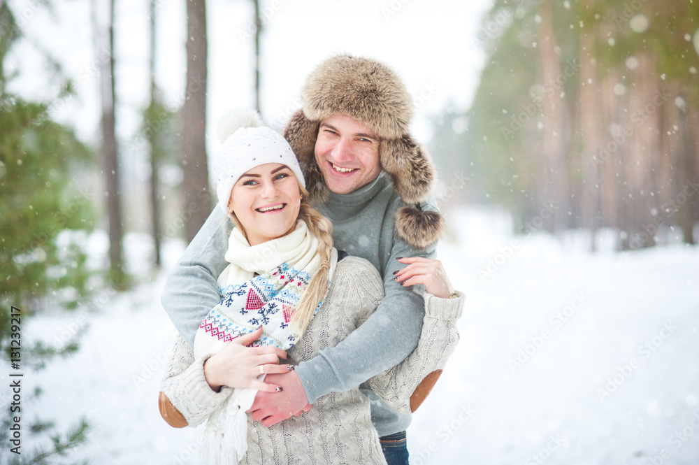 Couple walking in a winter forest, laughing, snowing Couple walking in a winter forest, laughing, snowing