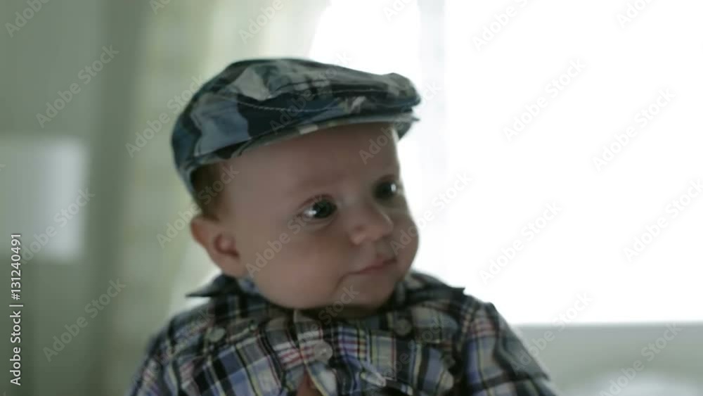 The frightened face of the baby in a plaid cap. The frightened face of the baby in a plaid cap.