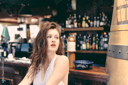 Beautiful girl in elegant dress at the pub bar