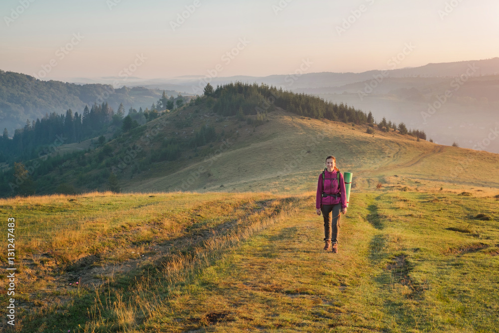 Young woman hiking with backpack in the mountain