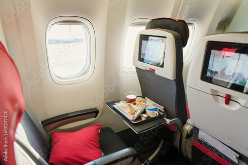 Seats on board of airplane. Cabin of economy class with screens