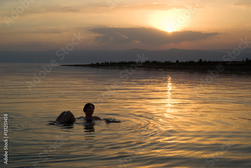 Woman floats in the Dead Sea at sunset  Jordan