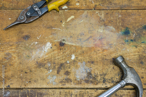 Hammer and pliers on worn wooden workshop background