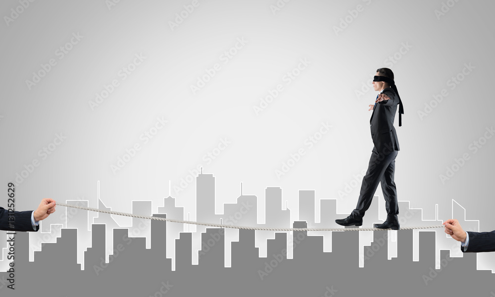 Business concept of risk support and assistance with man balancing on rope Business concept of risk support and assistance with man balancing on rope