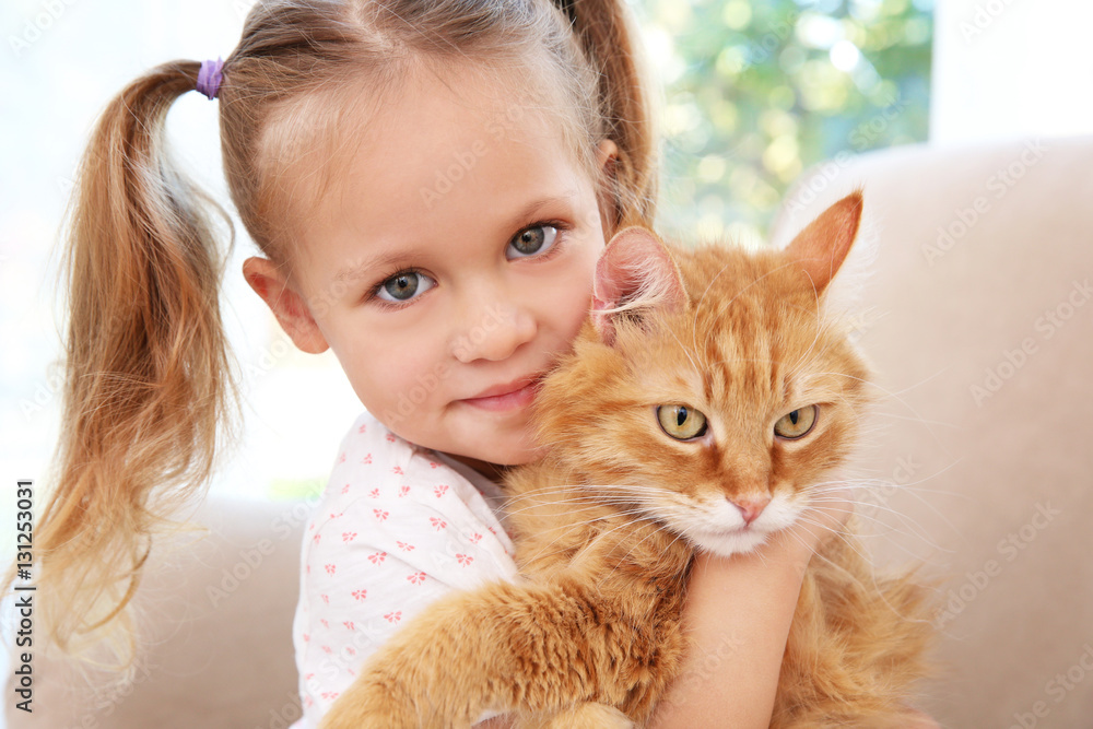 Cute little girl with red cat at home, close up Cute little girl with red cat at home, close up