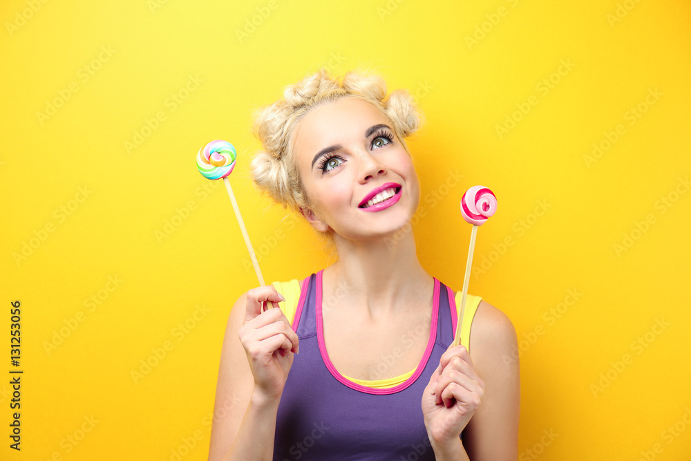 Beautiful woman with fashion hairstyle and lollipop on yellow background Beautiful woman with fashion hairstyle and lollipop on yellow background