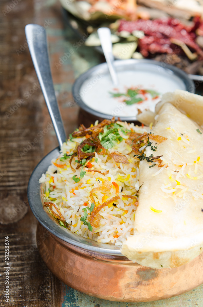 Authentic chicken biryani served with naan bread, fragrant pilau rice