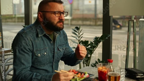 Man having toothache while eating in restaurant
