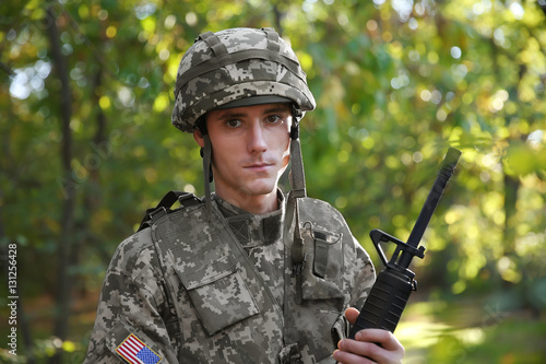 Portrait of soldier with rifle in forest