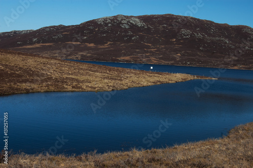 Small blue loch in Scottish Highlands on a beautiful sunny day