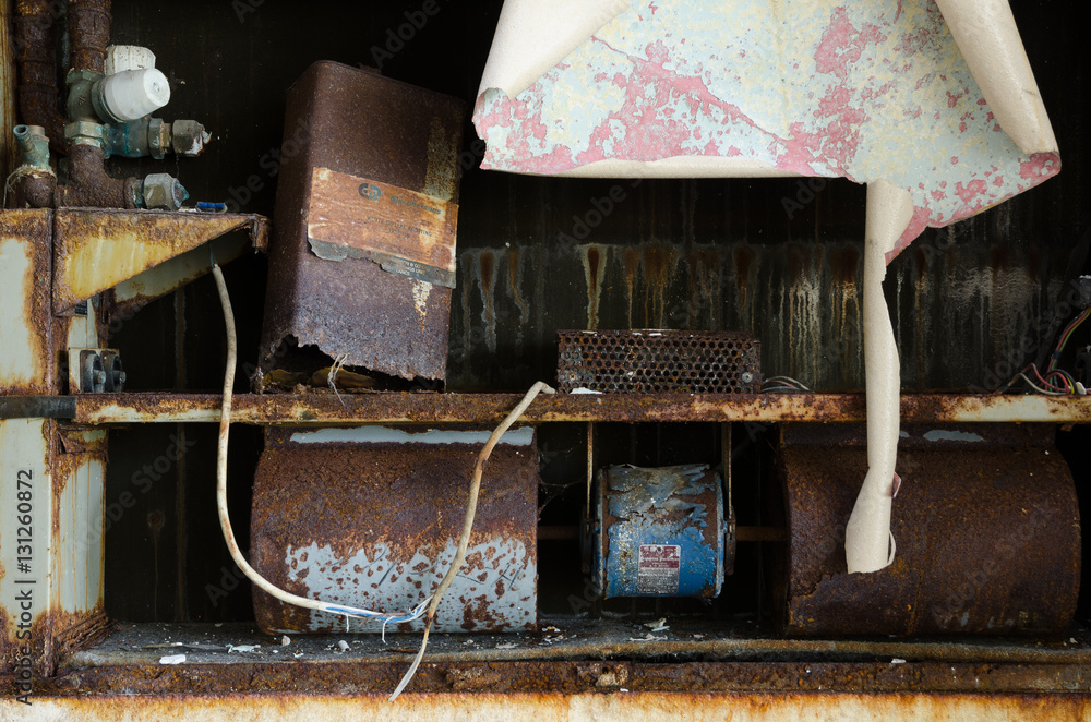 An old abandoned metal shelf withy rusty cans and pipes, in a decaying ...