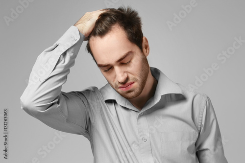 Depressed young man on grey...