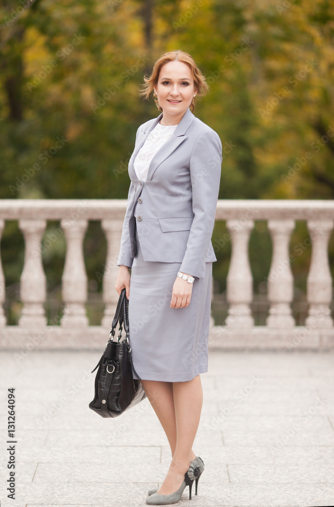 Fototapeta premium Red haired business women in grey suit