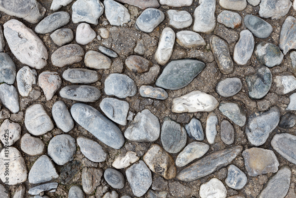 The texture of the old pavement of randomly laid cobblestones